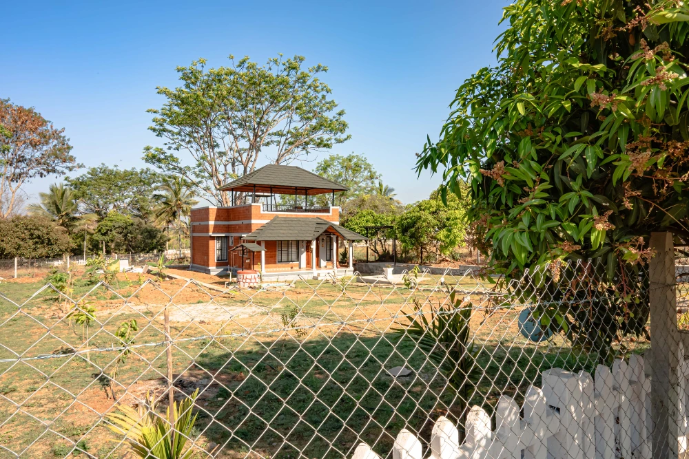 Independent house at vasudha kalpataru with a small garden and scenic natural views.