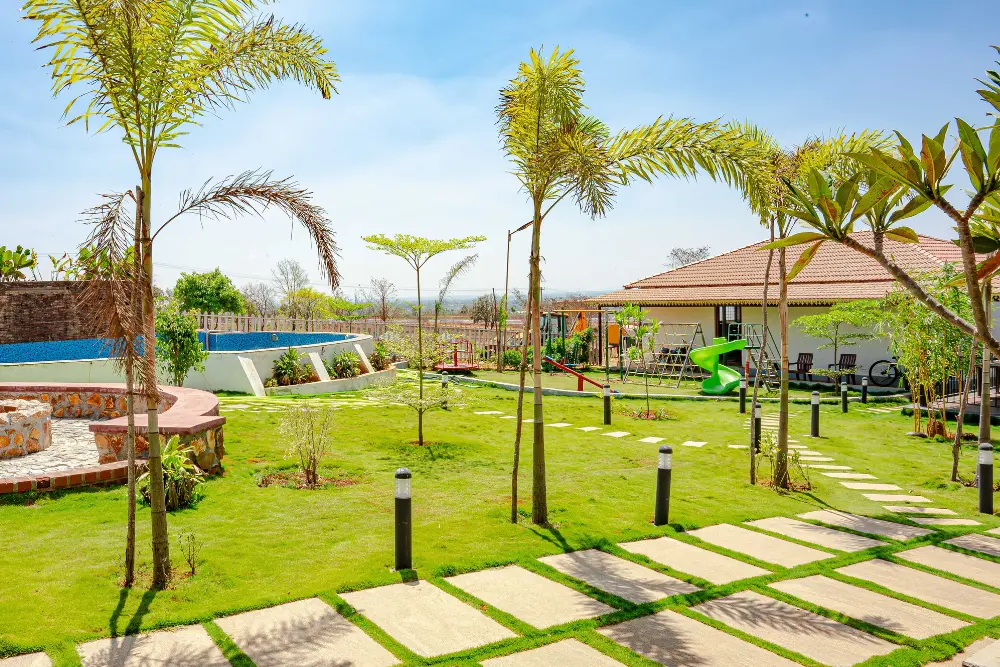 Landscaped entrance pathway at tamara valley with greenery and open surroundings.